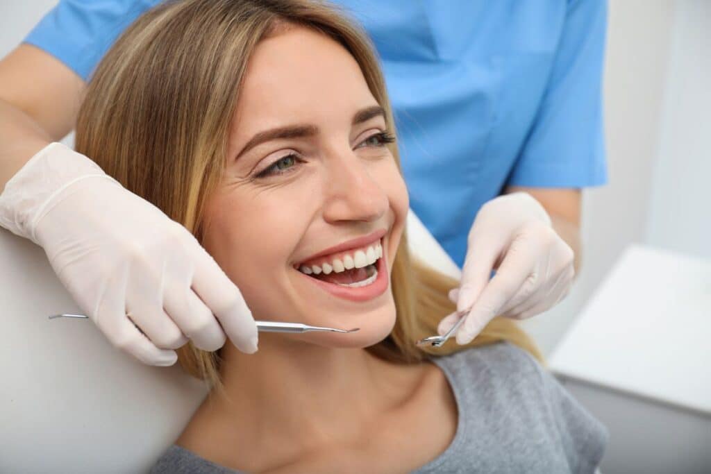 girl smiling after getting treatment from cosmetic dentist