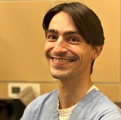 Smiling male dentist in light blue shirt at Bellevue dental practice.
