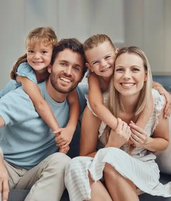 Happy family of four smiling together at a Bellevue dental practice.